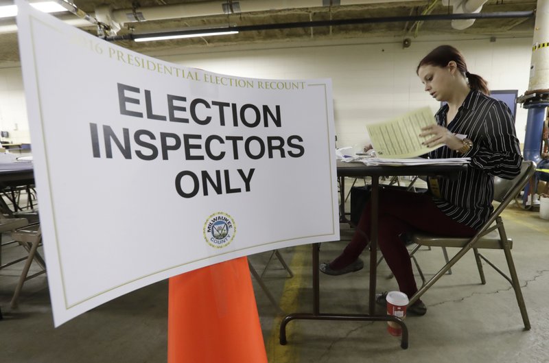Nicole Kirby looks over results during a statewide presidential election recount Thursday, Dec. 1, 2016, in Milwaukee. The first candidate-driven statewide recount of a presidential election in 16 years began Thursday in Wisconsin, a state that Donald Trump won by less than a percentage point over Hillary Clinton after polls long predicted a Clinton victory. 