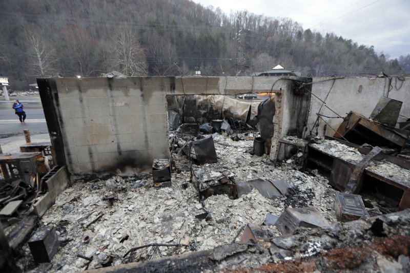 Some walls of a burned-out business remain Wednesday, Nov. 30, 2016, in Gatlinburg, Tenn., after a wildfire swept through the area Monday. Three more bodies were found in the ruins of wildfires that torched hundreds of homes and businesses in the Great Smoky Mountains area, officials said Wednesday. 