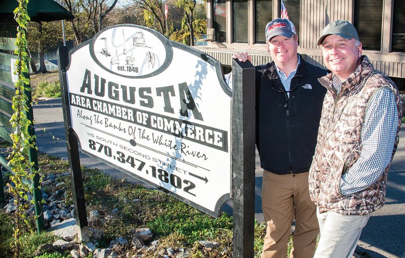 Chris Eldridge, left, Augusta Area Chamber of Commerce board member, and Boyd Wright, a fellow board member who has helped start the inaugural Mallard Masters Championship, stand by the sign between the White River and the location for the event in downtown Augusta. The championship, which was designed to promote tourism and raise scholarship money, will take place Saturday.