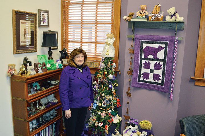 University of Central Arkansas Registrar Becky Rasnick of Conway stands in her office with some of the hundreds of bears she has collected over the years. Rasnick keeps the Christmas tree up year-round, she said. Students, co-workers and her family have given her bears to represent UCA’s mascot — and she made the bear quilt.