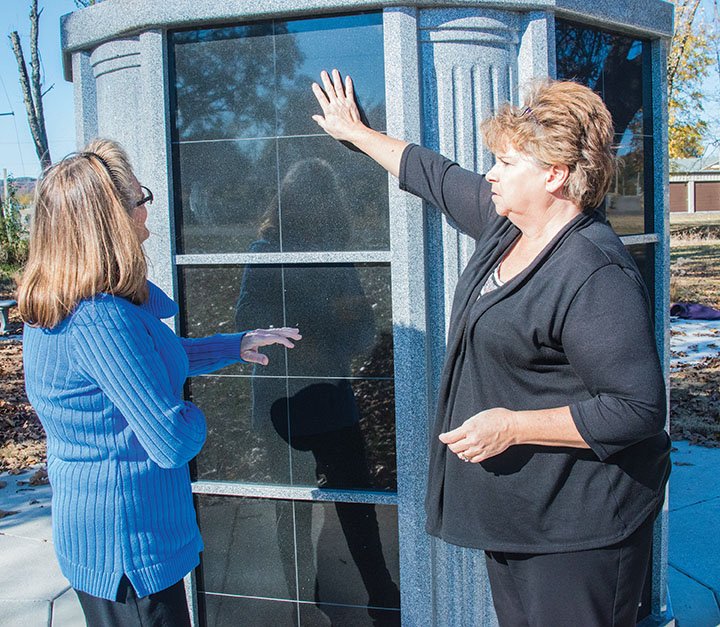 Joy Smolinski, left, assistant director of the Oakland Cemetery, and Stephanie Warwick, director, look at the 72-niche columbarium purchased and installed a year ago in the city-owned cemetery at Eighth and Detroit streets. A garden to complement the columbarium was completed a couple of weeks ago, Warwick said, and columbarium spaces are available.