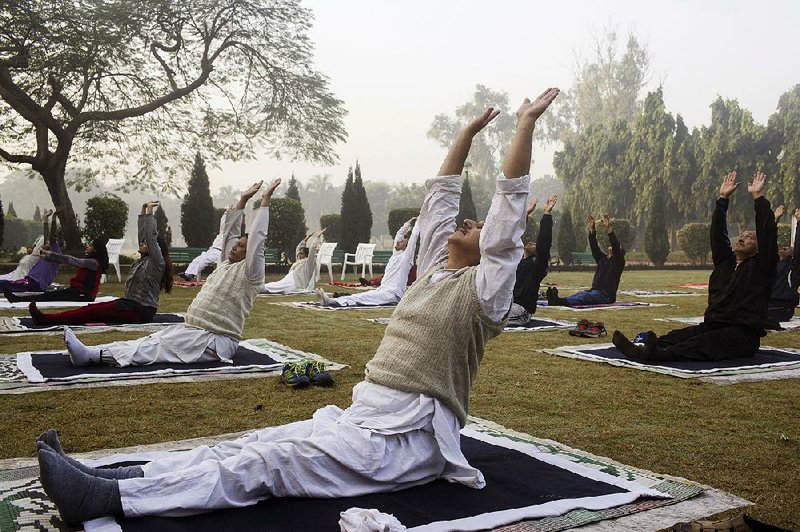 People stretch while doing yoga at Nehru Park in New Delhi, India, in November.