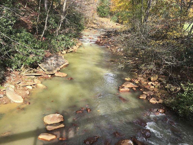 In this photo taken in early November, the Muddy Creek appears milky green, still showing signs of aluminum in the Cheat River tributary that was hit first and hardest by tainted water gushing from an abandoned mine that gave out in 1994.