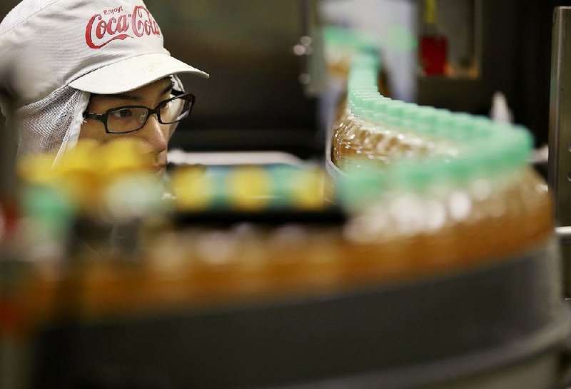 A worker watches a product line in November at the Coca-Cola Ebina plant in Ebina, Kanagawa prefecture, near Tokyo.