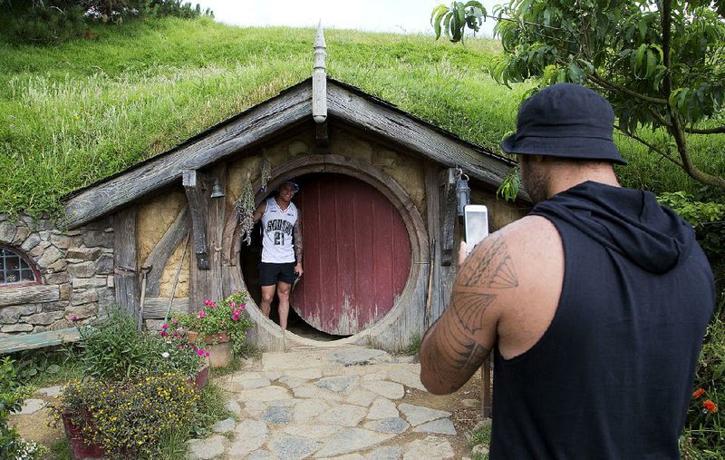 Tourists visit The Hobbit movie set near Matamata, New Zealand. Peter Jackson’s movie adaptations continue to give New Zealand tourism a boost. 
