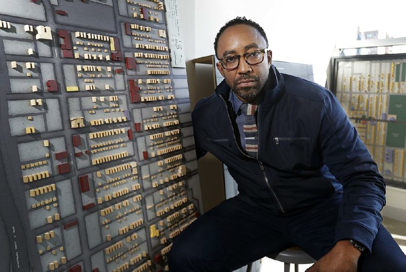Hajj Flemings, who won nearly $165,000 from the Knight Foundation Cities Challenge competition last year, sits next to a neighborhood model at the Detroit Center for Design and Technology.