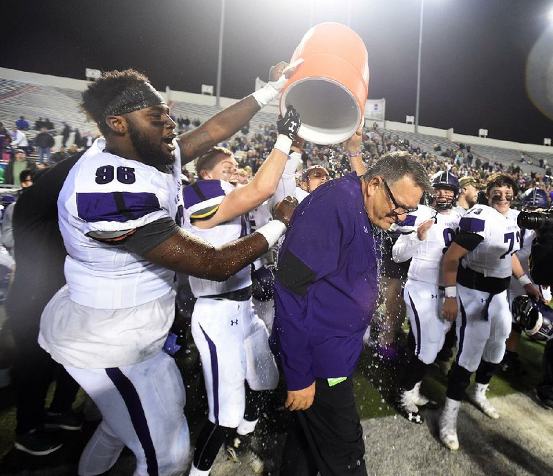 Fayetteville players dump water on coach Bill Blankenship after defeating North Little Rock on Dec. 2 to claim the 7A championship at War Memorial stadium in Little Rock.