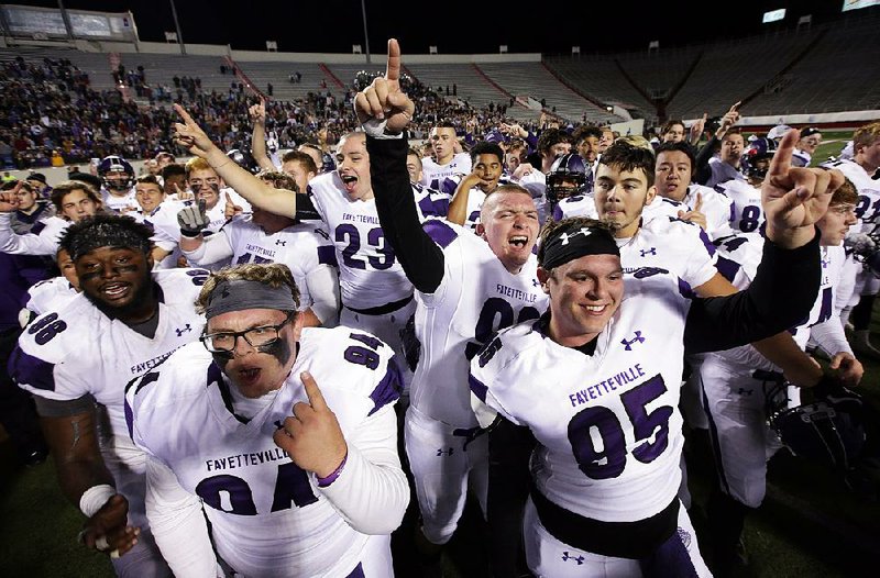 Fayetteville players celebrate after the Bulldogs’ victory over North Little Rock in the Class 7A championship game at War Memorial Stadium in Little Rock. It was the Bulldogs’ second consecutive state title and fifth overall.