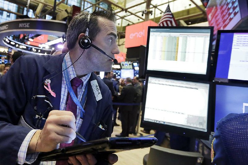 Trader Gregory Rowe works Friday on the fl oor of the New York Stock Exchange.