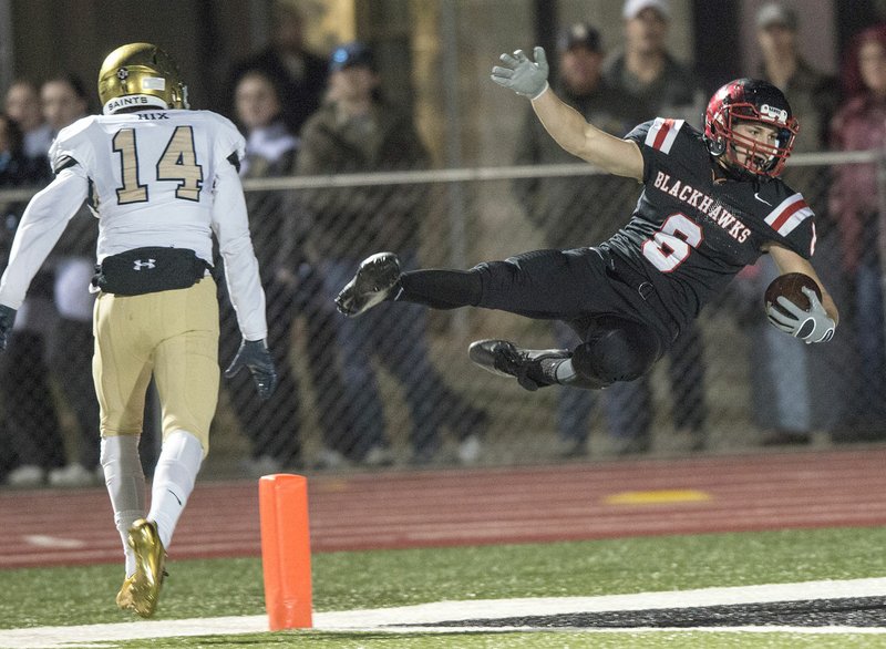 Drew Winn of Pea Ridge falls into the end zone for a touchdown as Austin Hix of Shiloh Christian defends Friday at Blackhawks Stadium in Pea Ridge. The Blackhawks won 30-24 and will face Warren in the 4A State Championship.