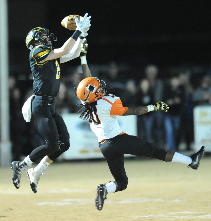 Isaac Disney (2) of Prairie Grove hauls in a pass over D’Shawn Jackson of Warren on Friday at Tiger Stadium in Prairie Grove.