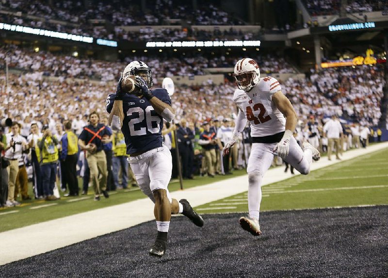 Penn State’s Saquon Barkley (26) makes an 18-yard touchdown catch in front of Wisconsin defender T.J. Watt during the second half of the No. 7 Nittany Lions’ 38-31 victory over the No. 6 Badgers on Saturday in the Big Ten Championship Game at Lucas Oil Stadium in Indianapolis.