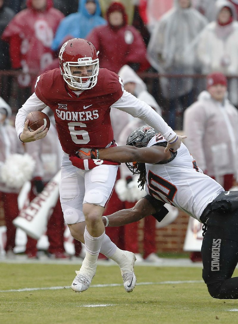 Oklahoma quarterback Baker Mayfield (6) tries to elude a tackle by Oklahoma State linebacker Jordan Burton (20) during the No. 9 Sooners’ 38-20 victory over the No. 10 Cowboys on Saturday in Norman, Okla.