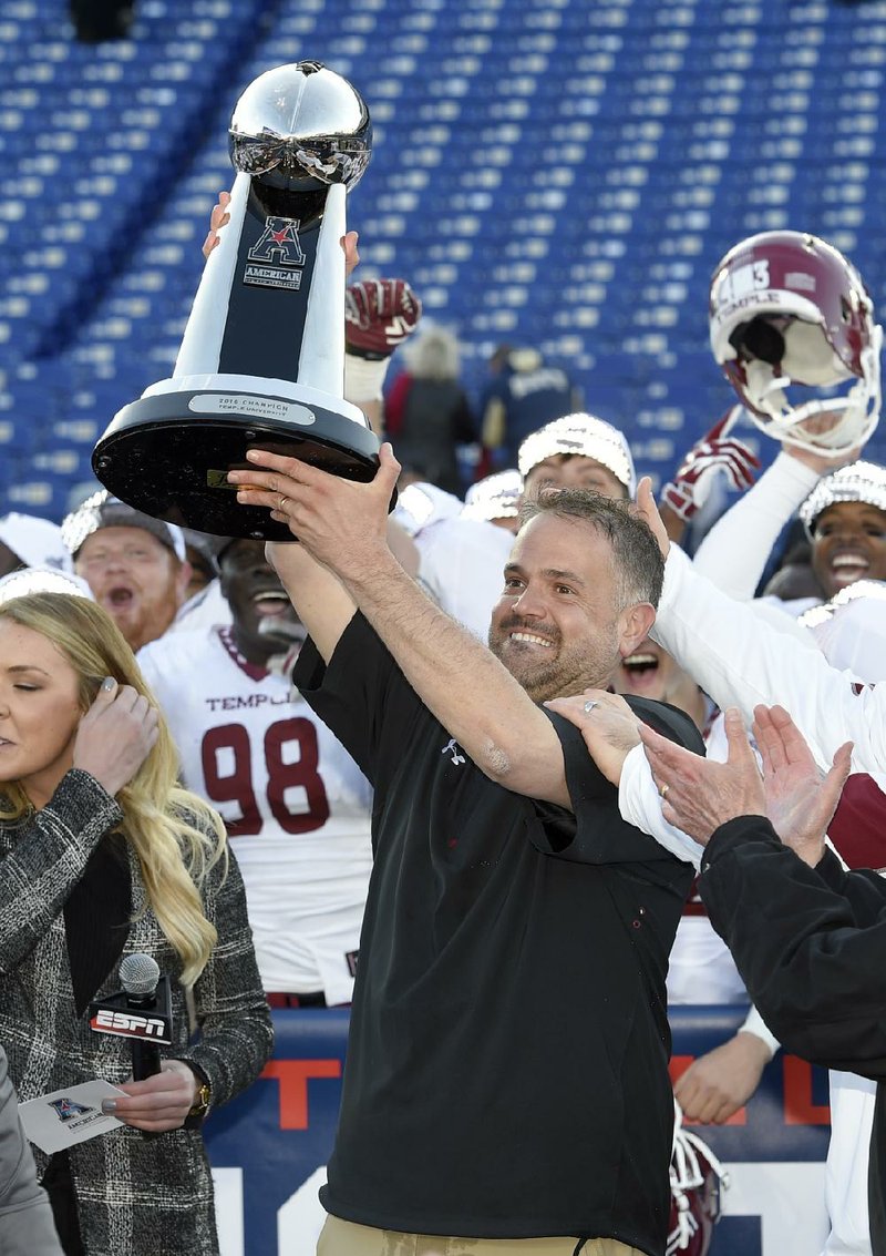 Temple Coach Matt Rhule lifts the American Athletic Conference championship trophy Saturday after the Owls defeated No. 19 Navy 34-10 in Annapolis, Md.