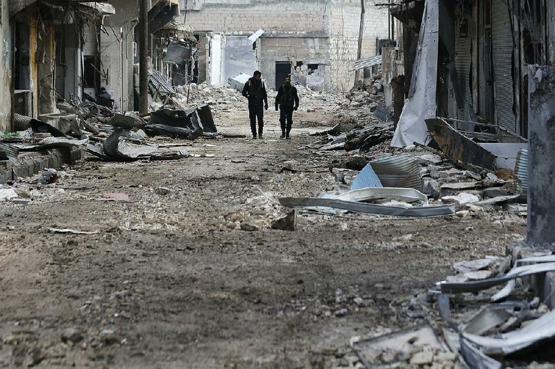 Syrian soldiers patrol Saturday in east Aleppo’s Tariq al-Bab district, where government forces made advances that cut the rebels’ territory.