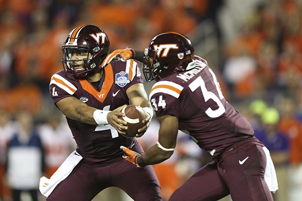 Virginia Tech quarterback Jerod Evans (4) hands the ball to running back Travon McMillan (34), during the first half of the Atlantic Coast Conference championship NCAA college football game against Clemson, Saturday, Dec. 3, 2016, in Orlando, Fla. (AP Photo/Willie J. Allen Jr.)

