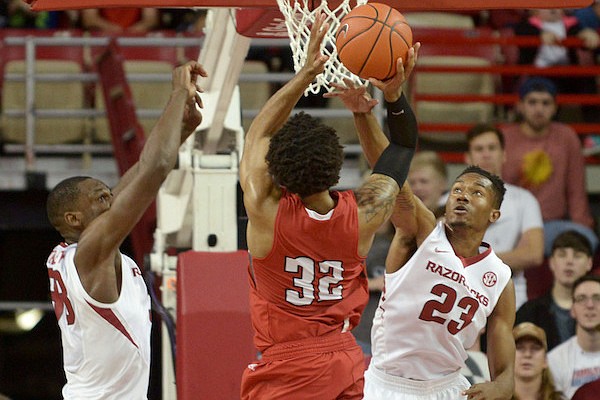 Moses Kingsley and C.J. Jones (23) of Arkansas guard as John Murry (23) of Austin Peay shoots on Saturday Dec. 3, 2016 during the game at Bud Walton Arena in Fayetteville.