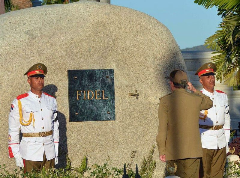 Cuban President Raul Castro salutes Sunday at the tomb of his older brother Fidel Castro at the Santa Ifigenia cemetery in Santiago, Cuba.