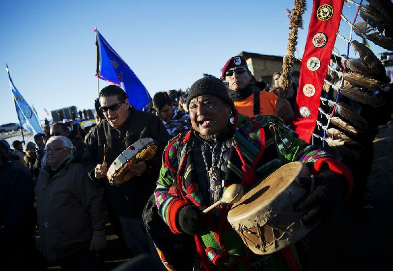 Dan Nanamkin of the Colville Nez Perce American Indian tribe in Nespelem, Wash., drums with a procession through the Oceti Sakowin camp in Cannon Ball, N.D., after it was announced Sunday that the U.S. Army Corps of Engineers won’t grant an easement for the Dakota Access oil pipeline.