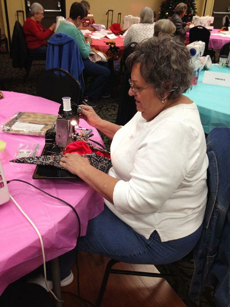 Diane Jones of Diamondhead, near Hot Springs, uses a vintage 1946 Singer sewing machine to sew a cap as part of the Care Cap Connection project.