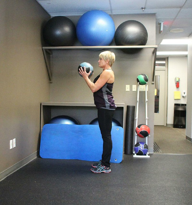 Robbin Benbrook does step 1 of the Wall Ball Burpee exercise 