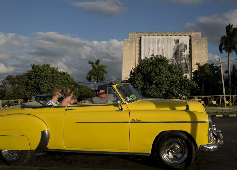 Tourists in a vintage 1950s Oldsmobile pass a depiction of Fidel Castro that covers a side of the National Library in Havana. Foreign investment in the tourism industry is only one of the government’s wishes included in a list of 395 investment opportunities published by the island nation’s government.