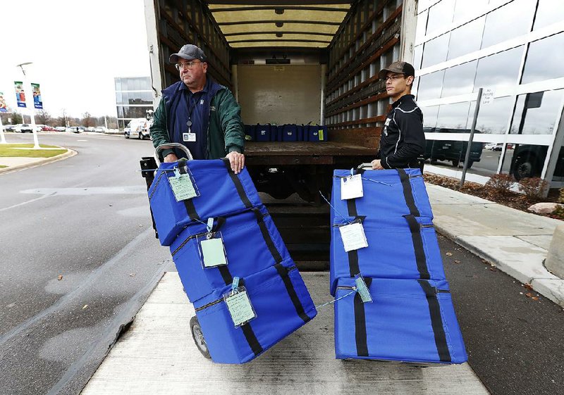 Ballots are unloaded during a statewide presidential election recount Monday in Waterford Township, Mich.