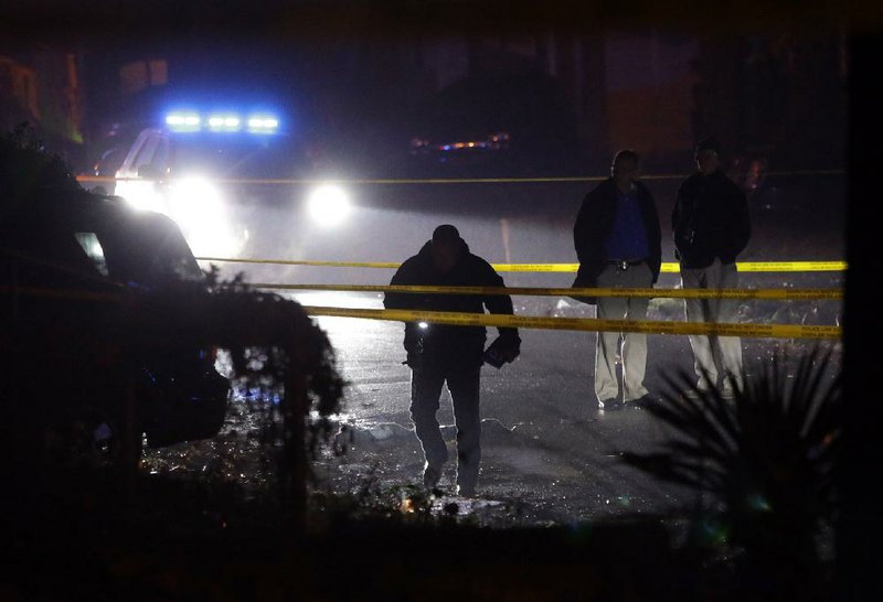 Little Rock police officers examine the scene of an officer-involved shooting at 34 Harrow Drive on Monday night.