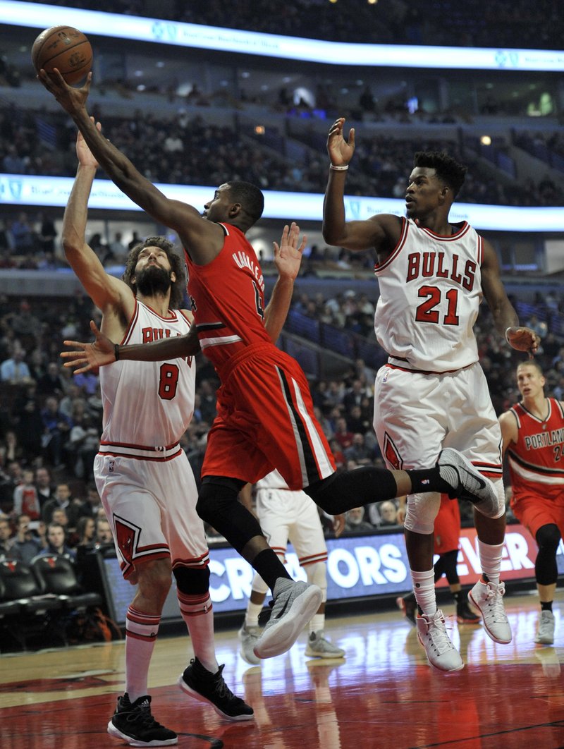 Portland Trail Blazers' Maurice Harmless (4) goes up for a shot against Chicago Bulls' Robin Lopez (8) and Jimmy Butler (21) during the first half of a basketball game Monday, Dec., 2016, in Chicago. (AP Photo/Paul Beaty)