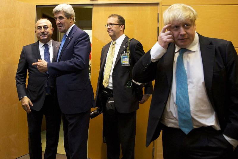 U.S. Secretary of State John Kerry (second from left) speaks with Turkish Foreign Minister Mevlut Cavusoglu (left) while British Foreign Secretary Boris Johnson (right) waits during a meeting on the sidelines of a NATO foreign ministers Tuesday at NATO headquarters in Brussels.