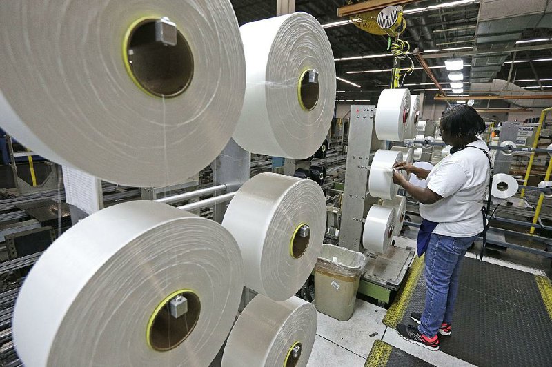 An employee at the Repreve Bottle Processing Center in Yadkinville, N.C., examines a spool of thread made from recycled plastic bottles in this file photo. A measure of American worker productivity increased in the third quarter, the Labor Department said Tuesday. 