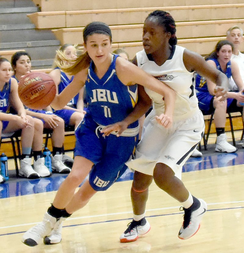 Photo courtesy of St. Gregory&#8217;s Sports Information John Brown University junior Kimmy Deines makes her way around a St. Gregory&#8217;s defender during Saturday&#8217;s game in Shawnee, Okla. The Golden Eagles defeated the Cavaliers 97-55 for their first Sooner Athletic Conference victory of the season.