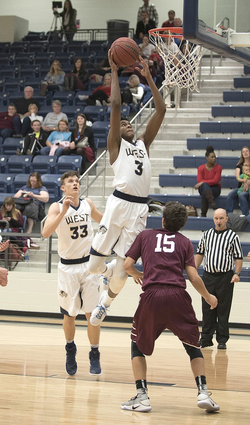 Bentonville West’s Gabe Hornsby (3) dunks over Huntsville’s Alex Pemberton on Tuesday at Wolverine Arena in Centerton.