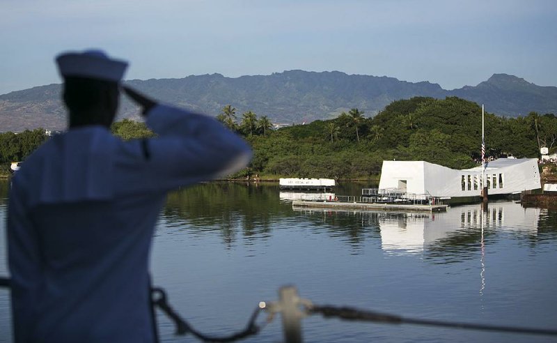 A sailor salutes the USS Arizona memorial Wednesday at Pearl Harbor as the USS Halsey sails by where the battleship was sunk in the Dec. 7, 1941, attack on the base in Honolulu. 
