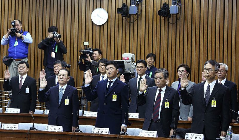 Witnesses take an oath during a hearing Wednesday in Seoul at South Korea’s National Assembly concerning the scandal that has embroiled President Park Geun-hye. 