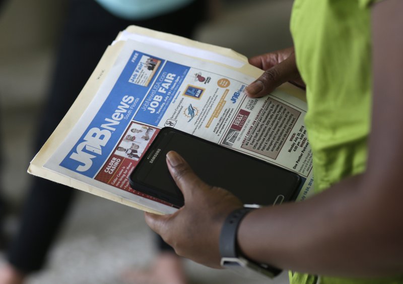 In this Tuesday, July 19, 2016, file photo, a job applicant attends a job fair in Miami Lakes, Fla. 