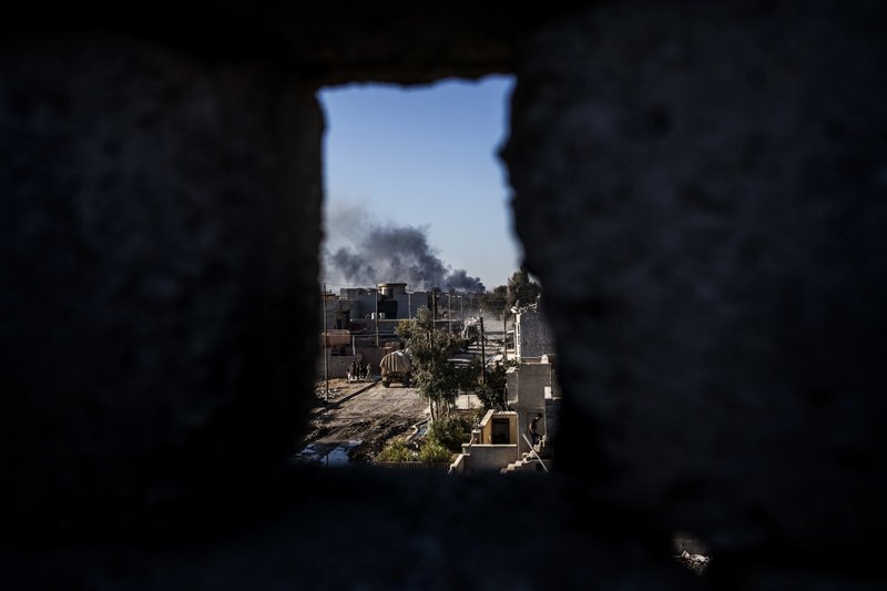 Smoke rises at the frontline, seen from an Iraqi army shooting position in Shyma district in Mosul, Iraq, Tuesday, Dec. 6, 2016. 