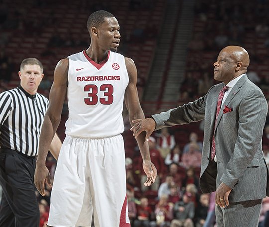 NWA Democrat-Gazette/Anthony Reyes CENTER OF ATTENTION: Arkansas head coach Mike Anderson talks with center Moses Kingsley (33) between plays against Houston Tuesday night at Bud Walton Arena in Fayetteville. With improved bench play this season, Anderson has been able to limit Kingsley's minutes.