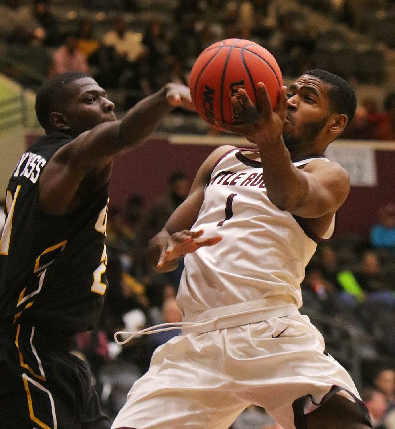 UALR guard Jalen Jackson (right) drives to the basket against UAPB’s Artavious McDyess during the Trojans’ 67-52 victory over the Golden Lions on Thursday at the Jack Stephens Center in Little Rock. Jackson scored 16 points for the Trojans.