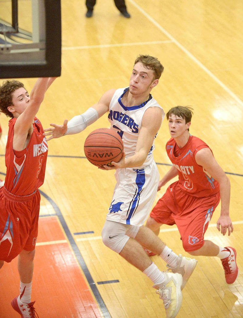 Jake Benninghoff of Rogers High shoots goes for a layup as Grant Ellis (3) of Webb City, Mo., defends Thursday during the Arvest Hoopfest tournament at War Eagle Arena in Rogers.