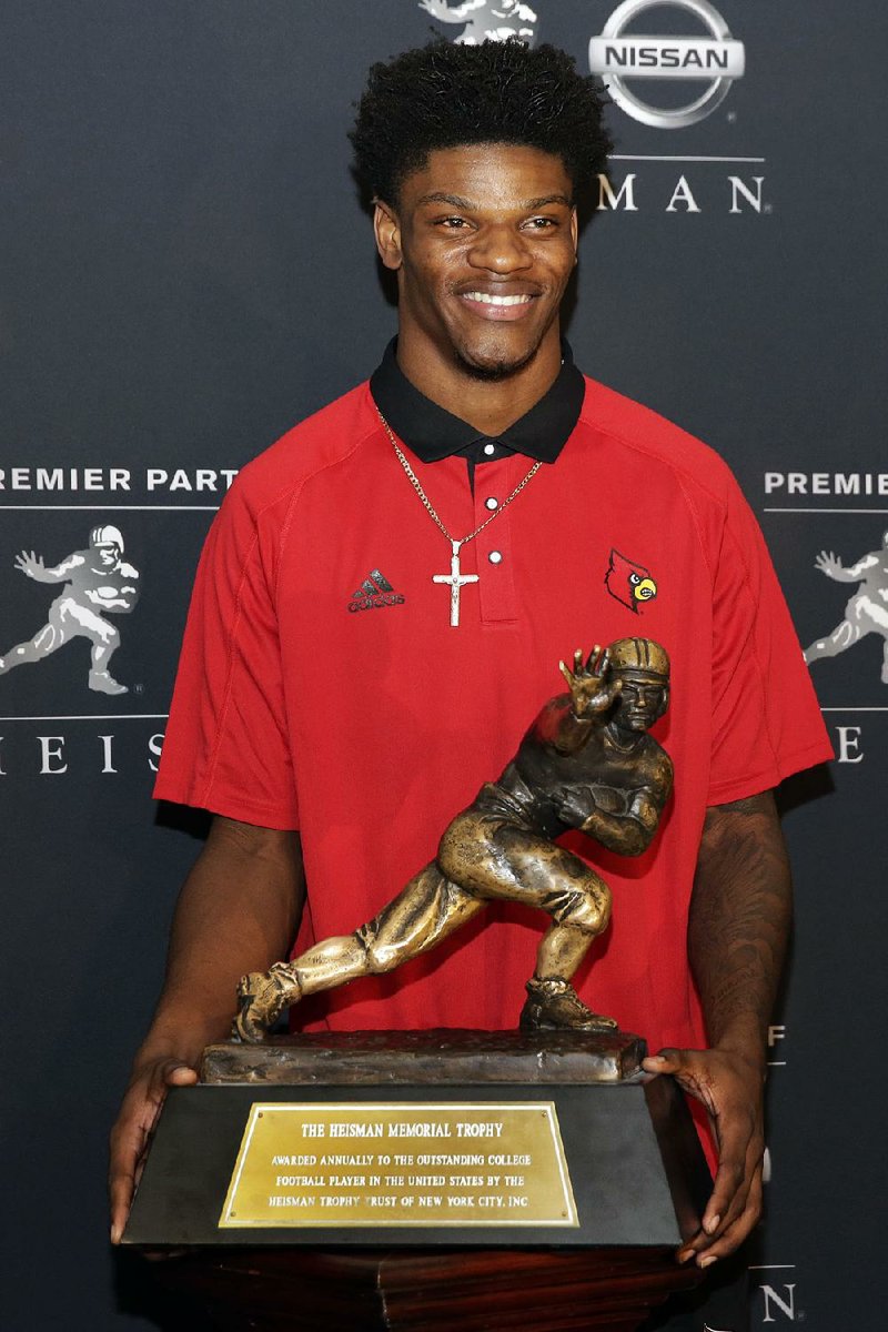 Heisman Trophy finalist from Louisville Lamar Jackson poses with the award in New York, Friday, Dec. 9, 2016.