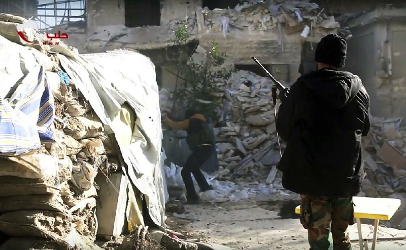 Rebel soldiers man a post Friday in eastern Aleppo, Syria, in this image taken from video. Government forces continued to gain ground in the city.

