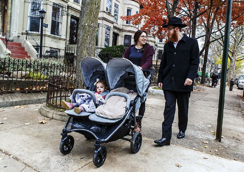 Rabbi Mendel Alperowitz walks with his wife, Mussie, and daughters in the Brooklyn borough in New York. The Alperowitzes are opening a Jewish community center in South Dakota.