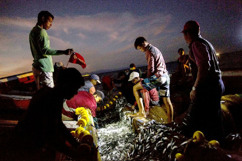 In late October, the Marval family members fish at night in the sea off Punta de Araya, Sucre state, Venezuela.