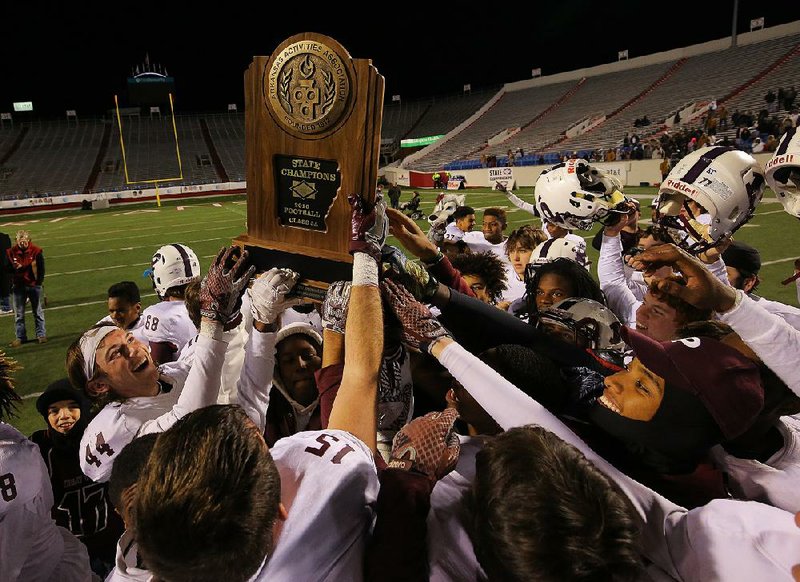 Members of the Prescott Curley Wolves celebrate with the state championship trophy after defeating Charleston 37-26 to claim the Class 3A title Saturday at War Memorial Stadium in Little Rock. More photos are available at arkansasonline.com/galleries.