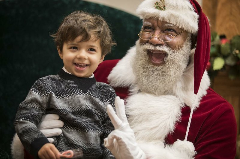 Arkansas native Larry Jefferson (right) smiles with Jack Kivel of Prior Lake, Minn., on Dec. 1. It was Jefferson’s first day as the first black Santa Claus in the history of the nation’s largest shopping mall, the Mall of America, in Bloomington, Minn.