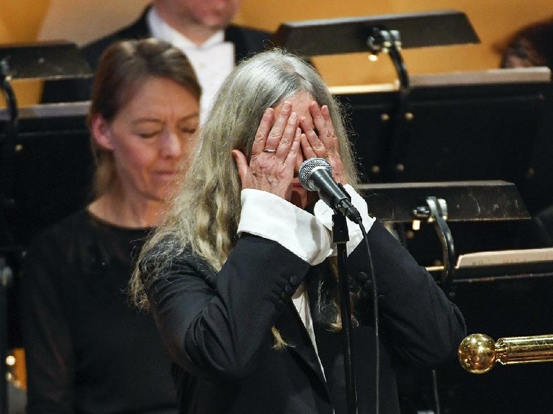 Singer Patti Smith covers her face after forgetting the lyrics to Bob Dylan’s “A Hard Rain’s a-Gonna Fall” during Saturday’s Nobel Prize award ceremony in Stockholm. “I’m so nervous,” she told the crowd, before having the orchestra restart the performance.