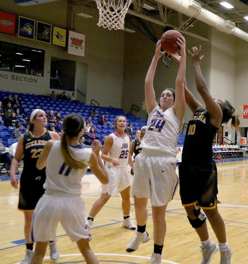 Photo courtesy of JBU Sports Information John Brown University sophomore Baily Cameron, No. 24, fights with Ecclesia&#8217;s Raquel Moore for a rebound during JBU&#8217;s 96-42 win over the Royals on Thursday at Bill George Arena.