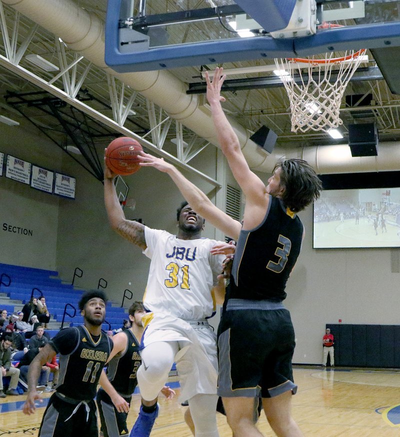 Photo courtesy of JBU Sports Information John Brown University freshman Brenton Toussaint takes the ball to the rim as Ecclesia&#8217;s Cacsh Krueger defends on the play during Thursday&#8217;s game at Bill George Arena. The Golden Eagles defeated the Royals 79-76.