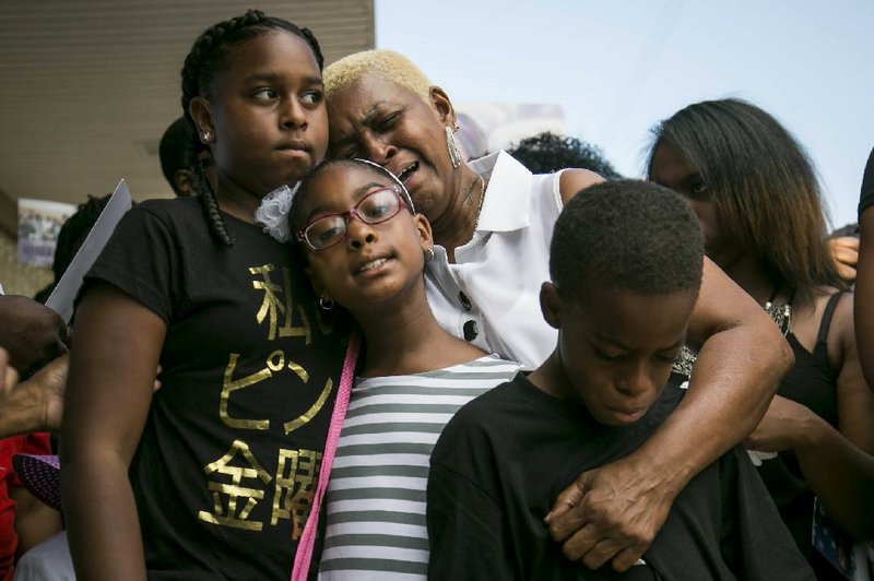 Diann Aldridge hugs her grandchildren, Summer, Sincere (right) and Shavae (center), during a vigil for their mother, Nykea Aldridge, in Chicago in August. Aldridge, a 32-year-old mother of four and the cousin of NBA star Dwyane Wade, was shot and killed while pushing her baby in a stroller.
